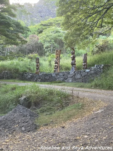 Picture of four tiki statues on the side of the road