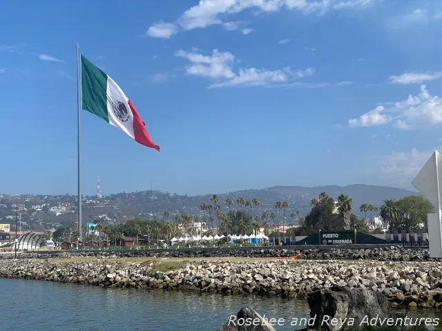 Picture looking out to the large Mexican flag on the waterfront boardwalk, the Malecon, from the Ensenada cruise port.